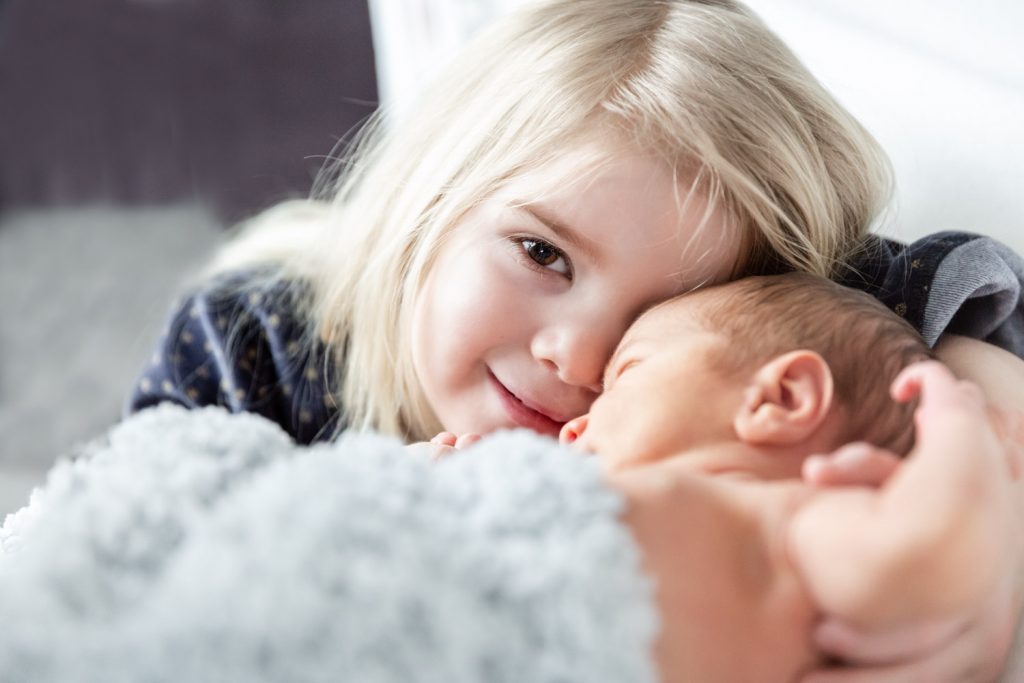 Portrait of a girl holding her newborn brother, Andrea Schenke Photography, Wittlich